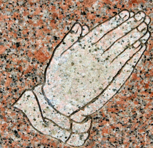 Praying hands in a gravestone